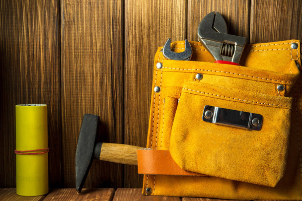 Tools and instruments in leather bag on wooden background. - Photo, Image