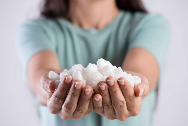 Close up mulher belas mãos segurando cubos de açúcar branco. Conceito de saúde
. - Foto, Imagem