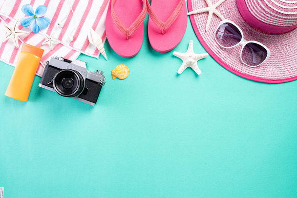 Beach accessories retro film camera, sunglasses, flip flop starfish beach hat and sea shell on green pastel background for summer holiday and vacation concept. - Φωτογραφία, εικόνα