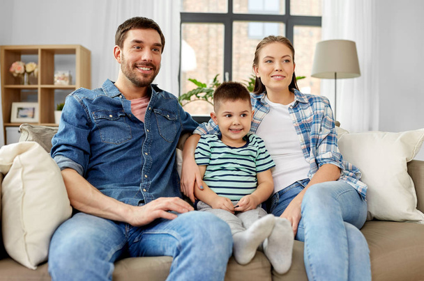 portrait of happy family sitting on sofa at home - Foto, Imagem