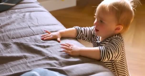 Cute baby standing leaning on bed - Felvétel, videó