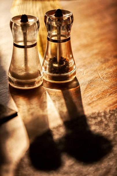 Рулет с солью и перцем на деревянном столе и естественным светом
. - Фото, изображение