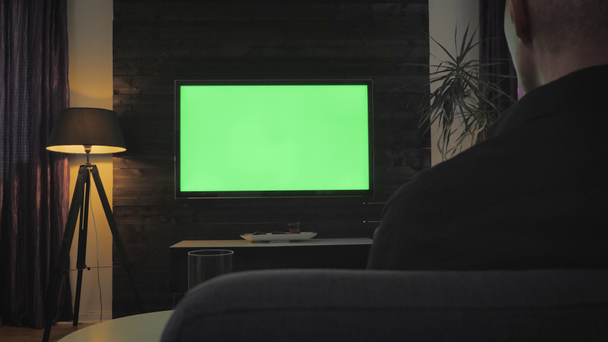 Pantalla verde - Hombre viendo la televisión en la sala de estar. Sobre el hombro disparar
. - Imágenes, Vídeo