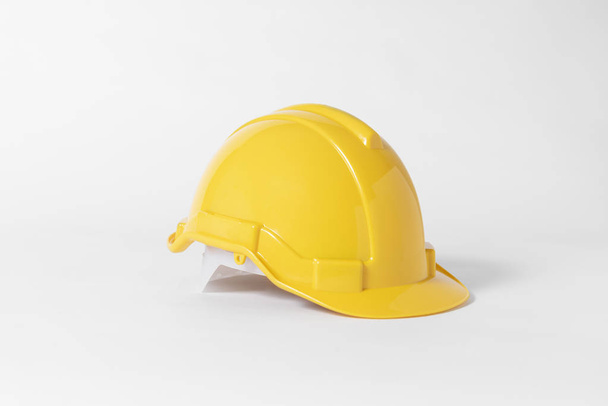 Yellow Plastic safety helmet for engineer on gray background. - Photo, Image
