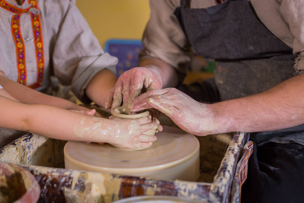 Potter showing how to work with ceramic in pottery studio - Foto, Imagen