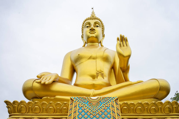 A grande estátua dourada de Buda fica alta e se destaca e é
 - Foto, Imagem