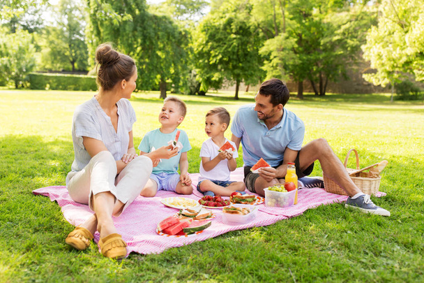 happy family having picnic at summer park - Foto, afbeelding