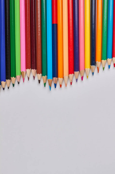 Різнокольорові дерев'яні олівці на білому тлі
. - Фото, зображення
