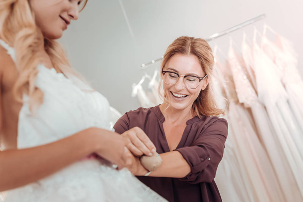 Tailor helping young woman with her wedding dress. - 写真・画像