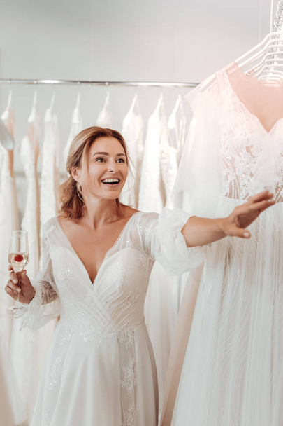 Gorgeous bride looking at dresses in the wedding salon. - Foto, Bild