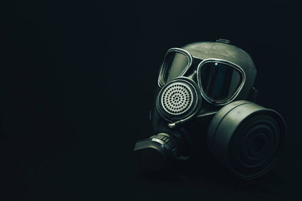 Газова маска на чорному столі і темний фон
.  - Фото, зображення