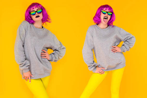 Wo λεσβιακό κορίτσι σε ροζ περούκα και ουράνιο τόξο γυαλιά ηλίου που θέτουν σε κίτρινο φόντο. - Φωτογραφία, εικόνα