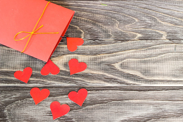 На темном деревянном фоне - сердца с окутанными подарками
 - Фото, изображение