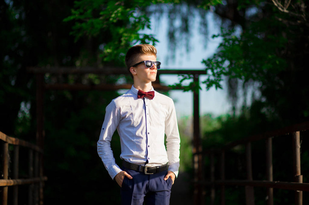 Πορτρέτο ενός νεαρού επιχειρηματία που φοράει λευκό πουκάμισο και γυαλιά ηλίου. Ο άνθρωπος με αυτοπεποίθηση κάνει σχέδια για το μέλλον. - Φωτογραφία, εικόνα