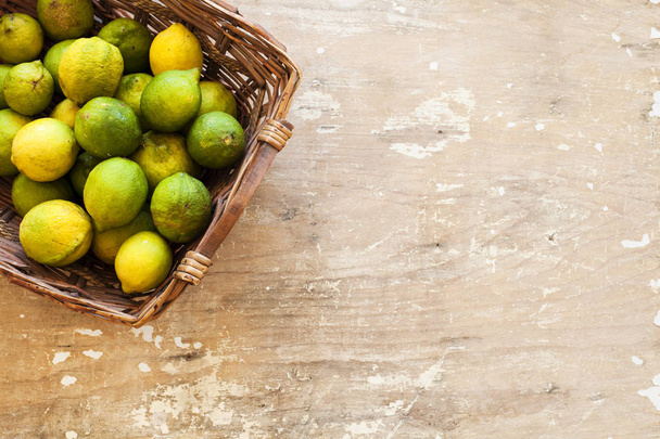Limone fresco con foglie. Limone. Scatola di limoni gialli con foglie fresche di limoni su fondo di legno. Vista dall'alto
 - Foto, immagini