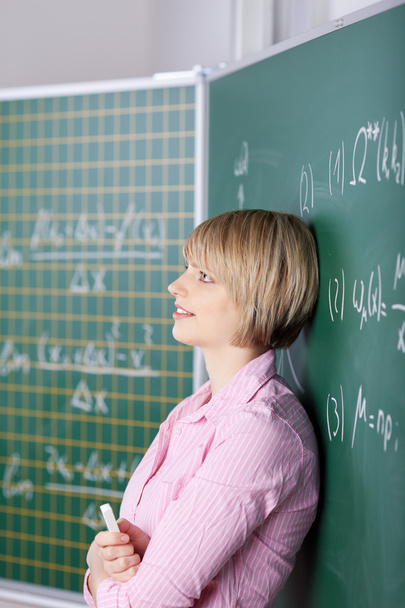 Student leaning against the blackboard - Zdjęcie, obraz