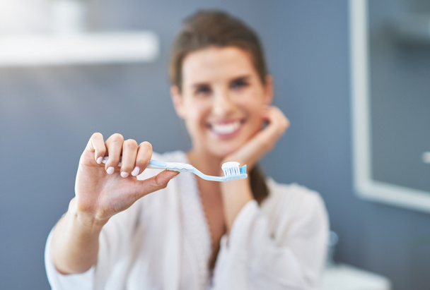 Красива брюнетка жінка чистить зуби у ванній
 - Фото, зображення
