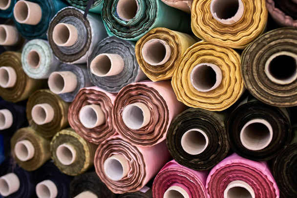 Fabric warehouse with many multicolored textile rolls - Fotografie, Obrázek