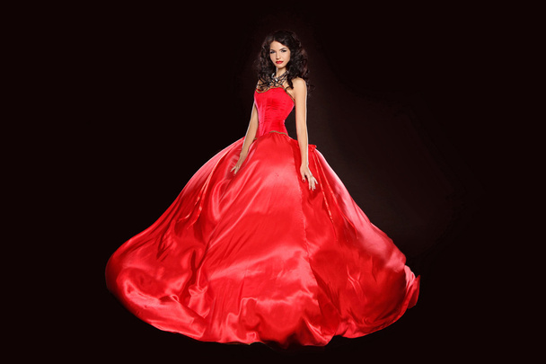 Beautiful woman wearing in magnificent red dress isolated on bla - Foto, afbeelding