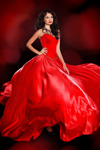 Beautiful woman wearing in magnificent red dress isolated on bla - Valokuva, kuva
