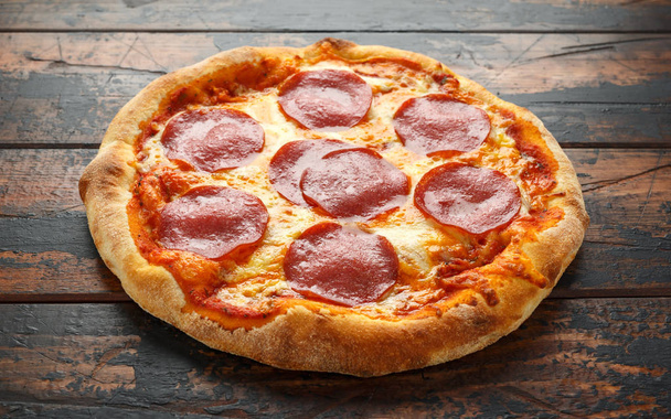 Peperoni, Salami-Pizza auf Holztisch. Fertig zum Essen - Foto, Bild