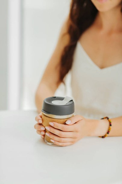 Female hands hold reusable coffee mug in a coffee shop. Sustainable lifestyle. Eco friendly concept. - Foto, Imagem