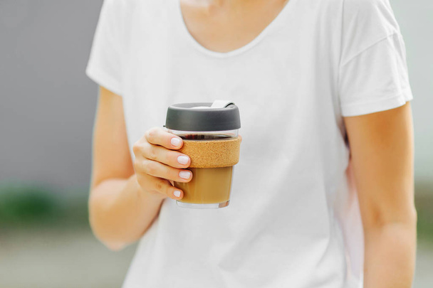 Female hands hold reusable coffee mug. Take your coffee to-go with reusable travel mug. Zero waste. Sustainable lifestyle concept - Фото, изображение