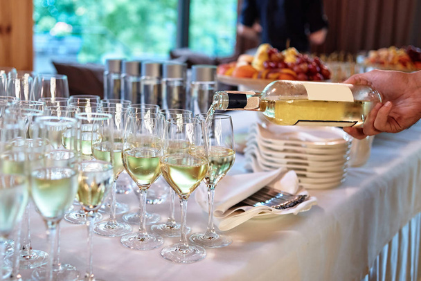 Garson düğün resepsiyonda şarap kadehine şarap döker, boşluk kopya - Fotoğraf, Görsel