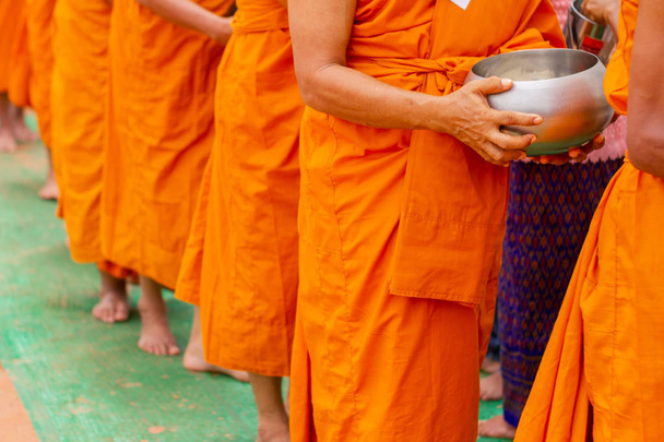 Volt egy érdem, hogy reggel. Az emberek sok szerzetes alamizsnájába kaparnák az ételt.. - Fotó, kép