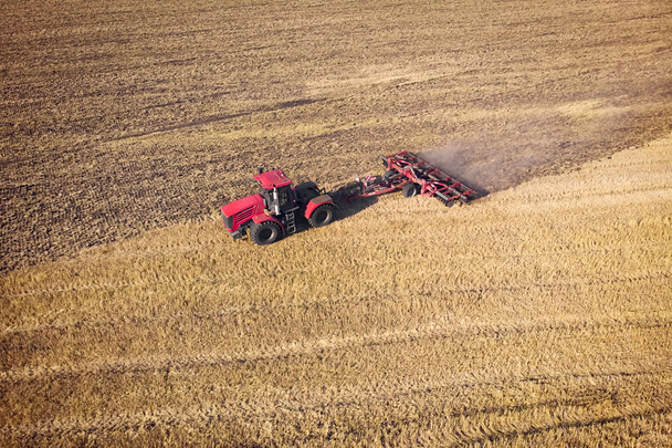 Tracteur travaillant dans les champs, vue aérienne. Du foin sur le terrain. La vue du haut. Le tracteur récolte de l'herbe sèche - Photo, image