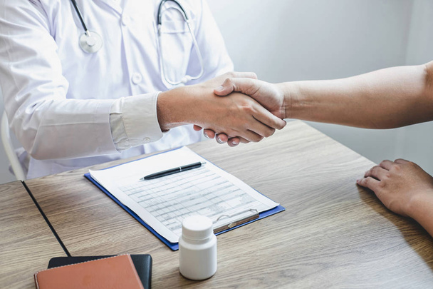 Doctor having shaking hands to congrats with patient after recom - Foto, immagini