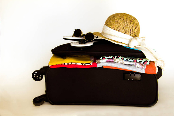 Holidays suitcase with clothes, hat sunglasses - Fotoğraf, Görsel