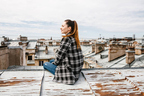 The girl on the roof of the house. - Fotoğraf, Görsel