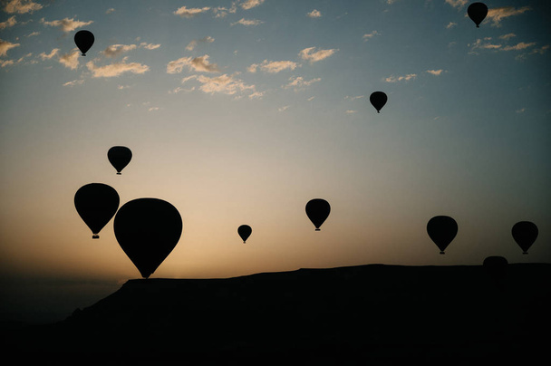 Hot air balloons landing in a mountain Cappadocia Goreme National Park Turkey. - Fotó, kép