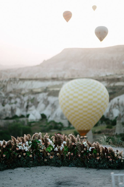 Hot air balloons landing in a mountain Cappadocia Goreme National Park Turkey. - Fotoğraf, Görsel