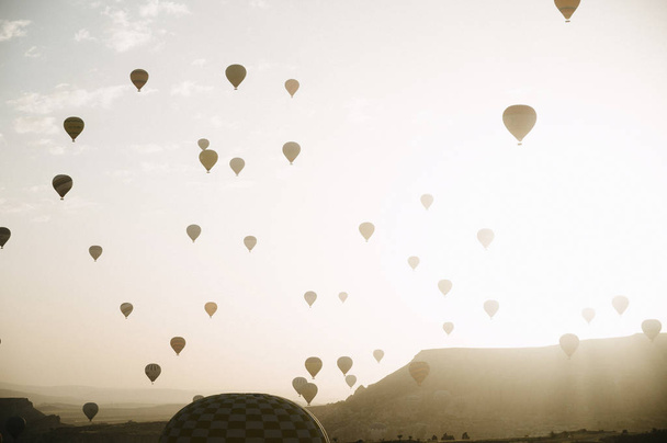 Hot air balloons landing in a mountain Cappadocia Goreme National Park Turkey. - Photo, image