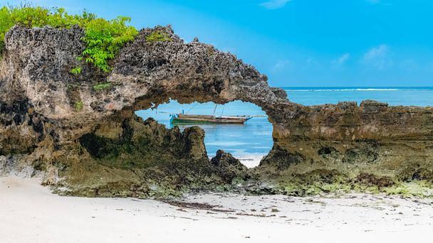 Zanzibar in Tanzania, beautiful beach with white sand, and a typical fishing boat - Photo, Image