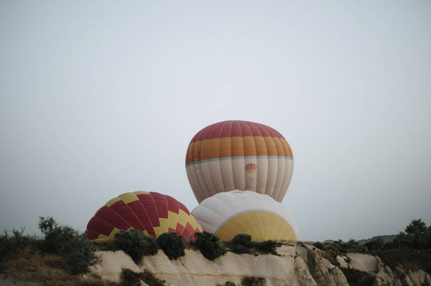Hot air balloons landing in a mountain Cappadocia Goreme National Park Turkey. - Foto, afbeelding