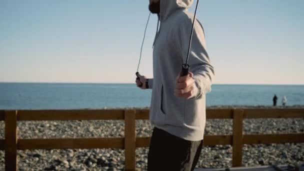 Ο πόλσμαν πηδάει σχοινί στην παραλία της πόλης κοντά στη θάλασσα το πρωί - Πλάνα, βίντεο