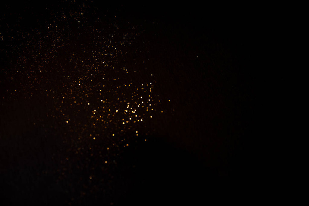 Golden abstract bokeh on black background. - Foto, Bild