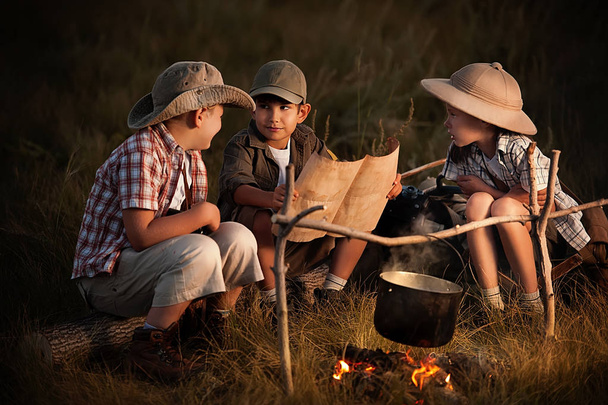 Group of children sitting around the campfire travelers  - Photo, Image