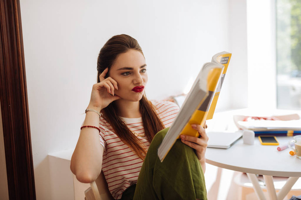 Emotional brunette girl reading book before exam - Foto, afbeelding