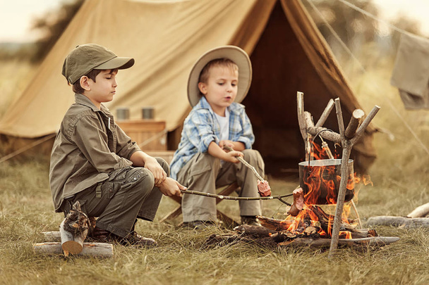 Two of children sitting around the campfire travelers  - Foto, immagini