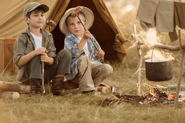 Two of children sitting around the campfire travelers  - Photo, Image
