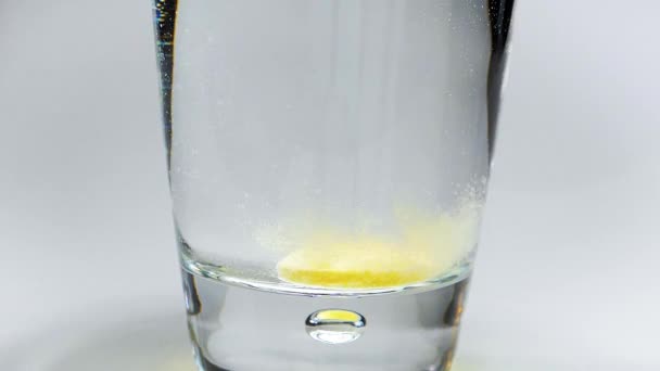 Effervescent tablet falling into glass of water - Materiał filmowy, wideo