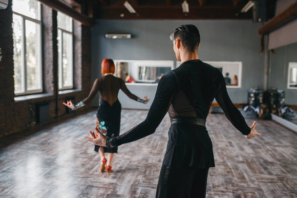 Férfi és nő a Ballrom tánc képzés osztályban. Női és férfi partnerek a profi pár tánccal a stúdióban - Fotó, kép