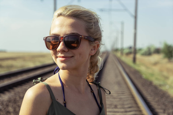 A young girl of 17 years old blonde with pigtails posing on a ra - Фото, зображення