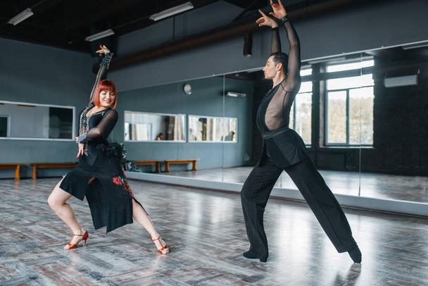 Κομψές χορεύτριες με κοστούμια στην προπόνηση χορού στην τάξη. Γυναίκες και άνδρες παρτενέρ σε επαγγελματικό χορό στο στούντιο - Φωτογραφία, εικόνα