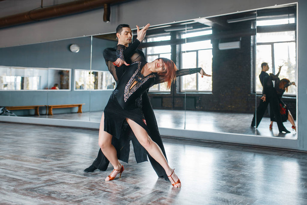 Two elegance dancers in costumes on ballrom dance training in class. Female and male partners on professional pair dancing in studio - Photo, Image