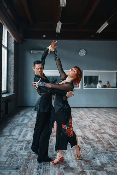Couple in costumes on ballrom dance training in class. Female and male partners on professional pair dancing in studio - Фото, зображення